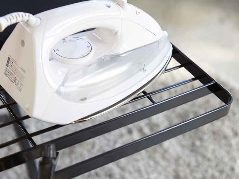 YAMAZAKI/toscaのスタンド式アイロン台。スチールと天然木を使用し、麻・綿の布地で覆われた家庭用小型家電がキッチンに設置されている様子。