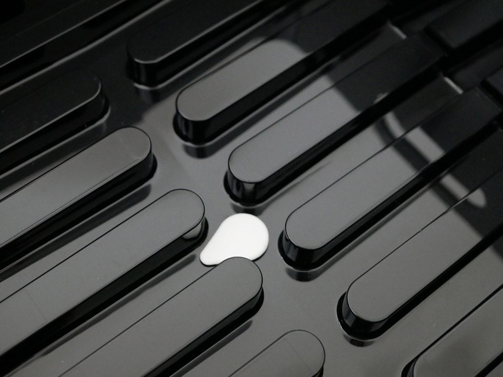 YAMAZAKIタワーのABS樹脂製水切りバスケットがキッチンカウンターに置かれ、食器を乾かしている様子