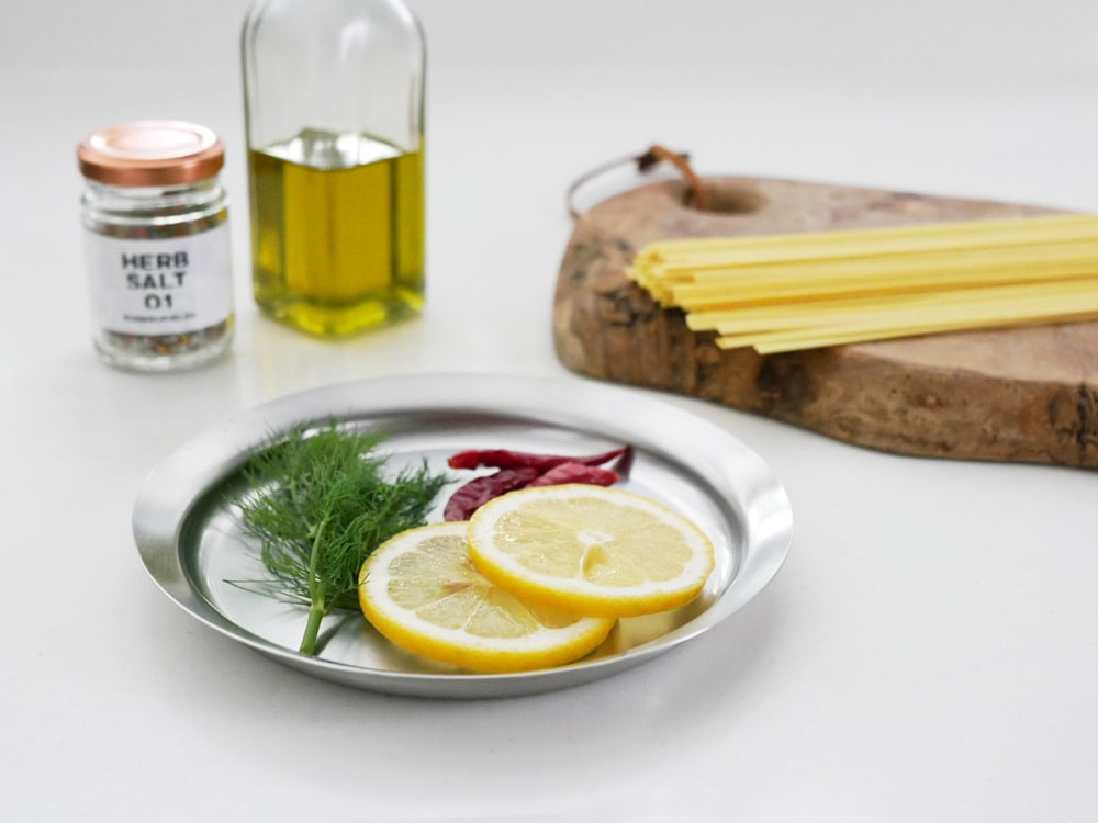 la baseの18-8ステンレス製ボウル、ざる、プレートが野菜と果物と共に並べられたテーブルウェアセット