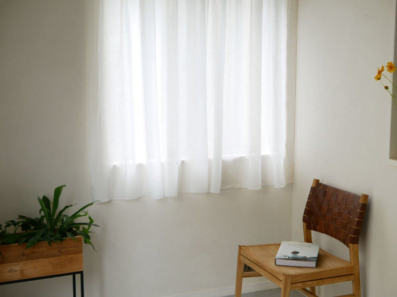 natsusobikuの麻100%リネンクリップ留めレースカーテンがリビングルームの窓に掛けられており、自然な風合いで室内を上品に演出しています