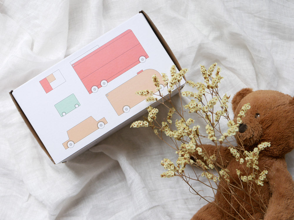 dou?の「ride in」玩具セット。21x9x12cmの布製消防車、木製のくるま3台、ブロック3個、約72x42cmの布製マップが含まれる安全なおもちゃ。