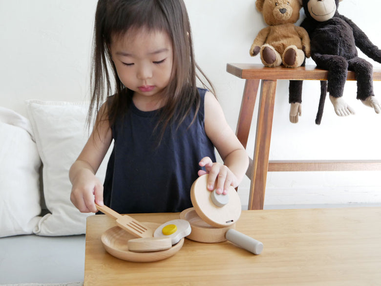 幼児が【dou】ままごとがっき pop panを使って料理ごっこをして遊んでいる様子