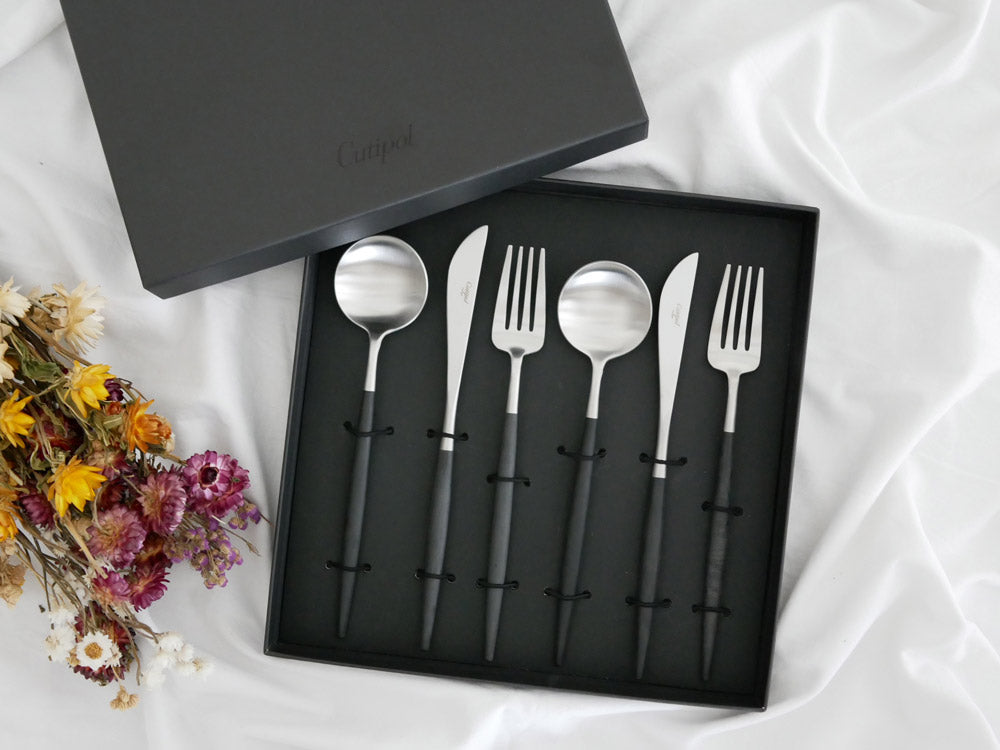 Cutipol製GOAカトラリーセット。マット仕上げのステンレスと樹脂で作られたディナーナイフ、ディナーフォーク、ディナースプーン、デザートフォーク、デザートスプーン、コーヒースプーンが整然と並んでいる様子。