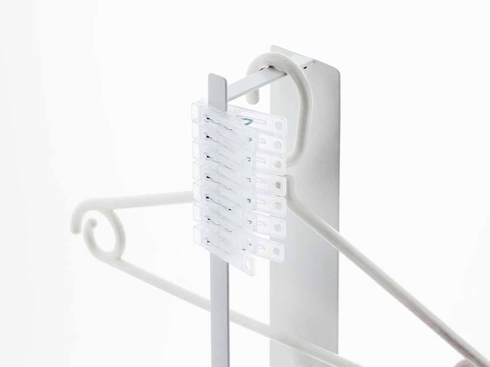 白色のYAMAZAKIタワーマグネット洗濯ハンガー収納ラックが壁に設置されている様子