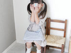 制服を着た幼児がABC木製カードを手に持っている様子