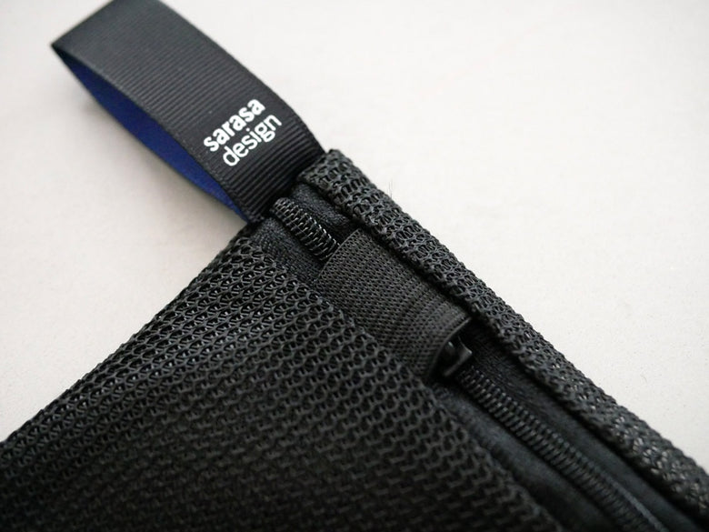 サラサデザインのフラットリバーシブルランドリーネット。ポリエステルとラテックス素材を使用し、ストラップとウェビングが特徴のメッシュ洗濯ネット