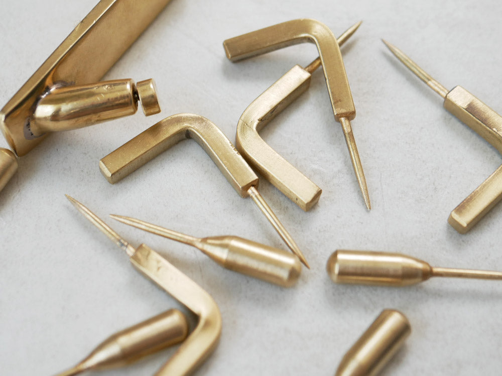 Horn Pleaseのアンティーク調真鍮製プッシュピンフック5個セットが並べられている様子。塗装のムラや錆び風合いが特徴的なデザイン。