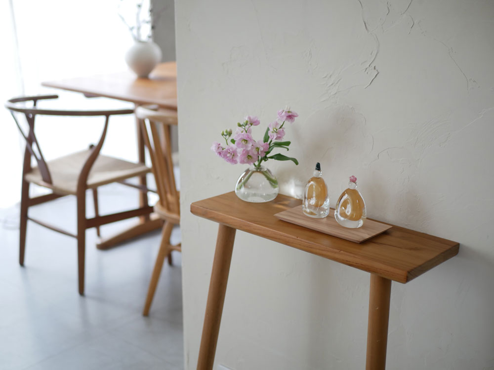 ガラスのお雛様が木製の飾り台と花瓶と共に美しく飾られている様子