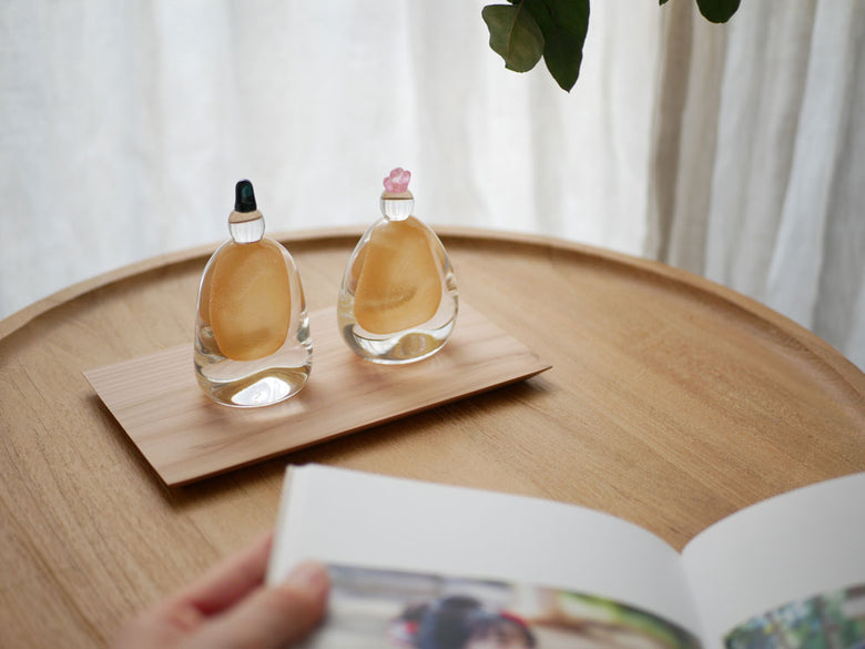 硝子屋 PRATO PINOの手作りガラス製お雛様が木箱と飾り台に配置された静物写真