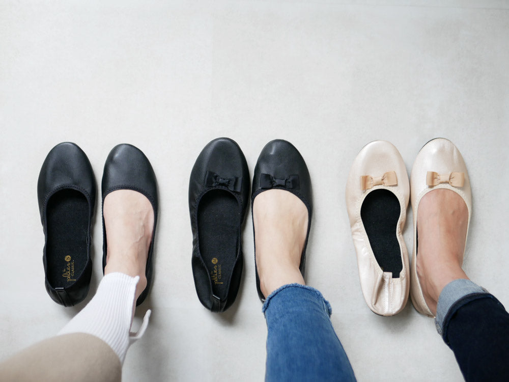 ブラウンのレザー製バレエフラットシューズ。リボン装飾と合成ゴムソールが特徴。