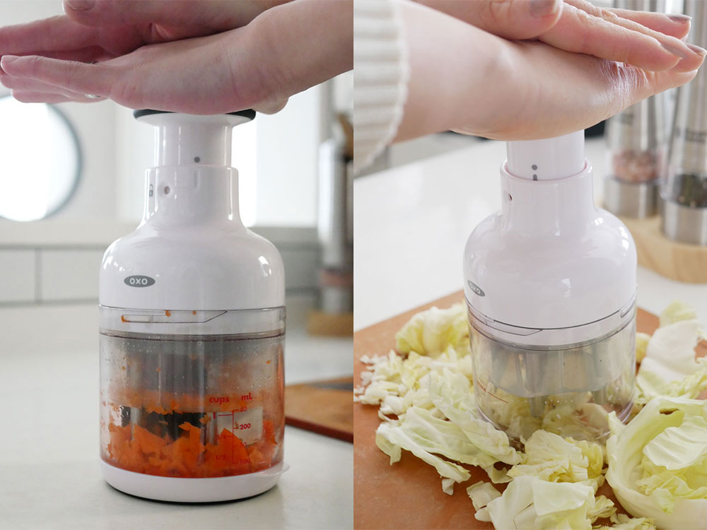 OXOオクソーの小型キッチンチョッパー、ステンレス製の刃と透明な容器が特徴的に並べられています。