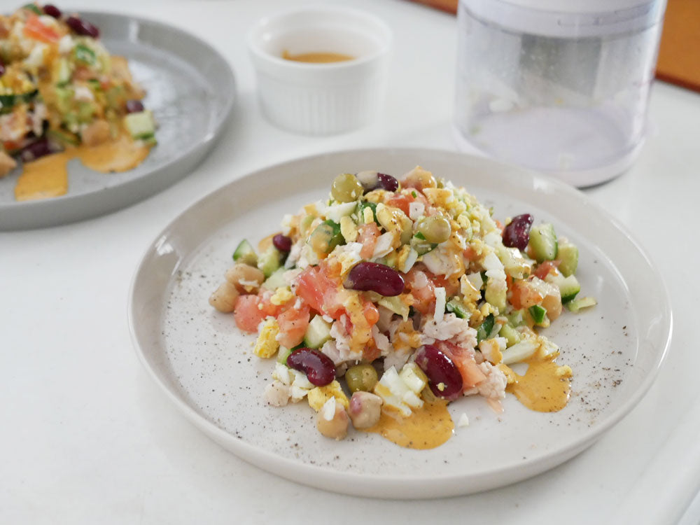 OXOチョッパーと新鮮な野菜や食材がテーブルに並べられている調理シーン