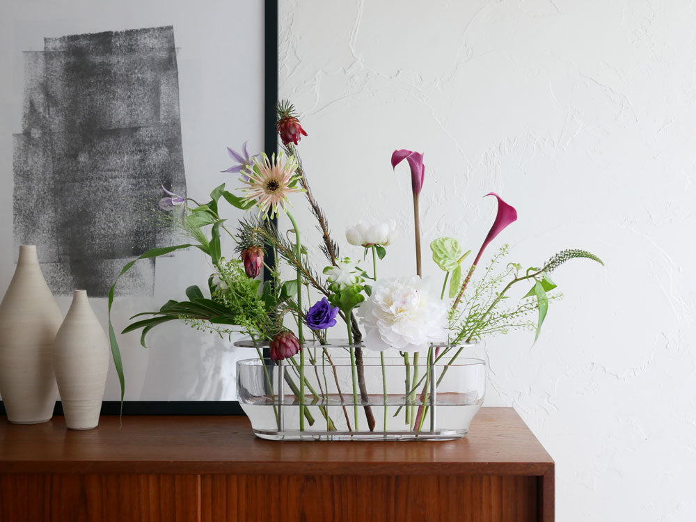 フリッツ・ハンセンのIKEBANA、ガラスと真鍮の花瓶にピンクの切花を活けたエレガントなフローラルデザイン