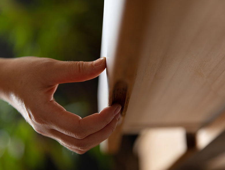 アデペシュ POL ポル デスクの上で手首や指を使って操作している様子。スチール焼付け塗装のフレームとオーク無垢材の天板が特徴的です。