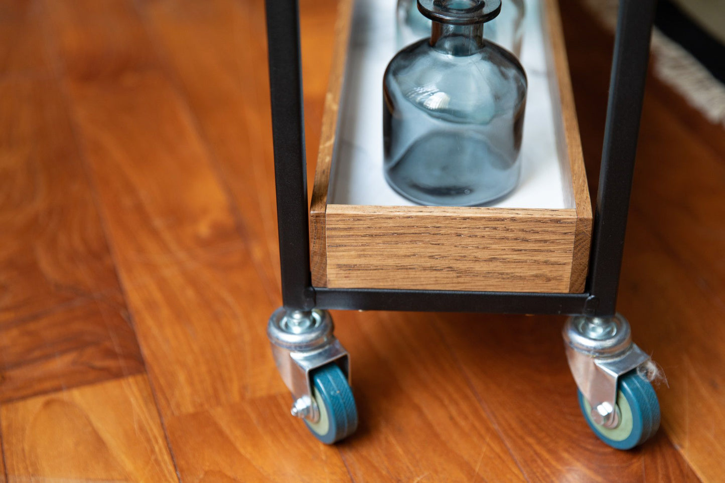 アデペシュ POL ポル ムービングワゴンの木製キッチンカート。スチールフレームにオーク無垢材の棚があり、ボトルが並べられたデザイン