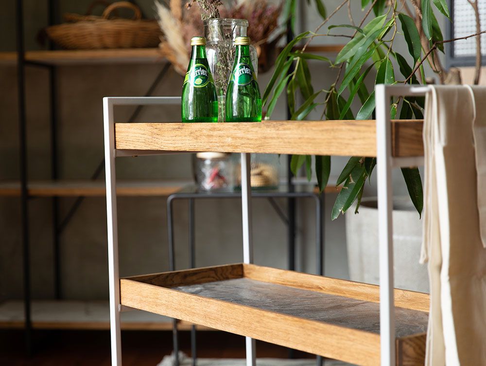 adepecheのPOLポルムービングワゴンが収納棚に配置され、果物や植物が並ぶインテリアの風景