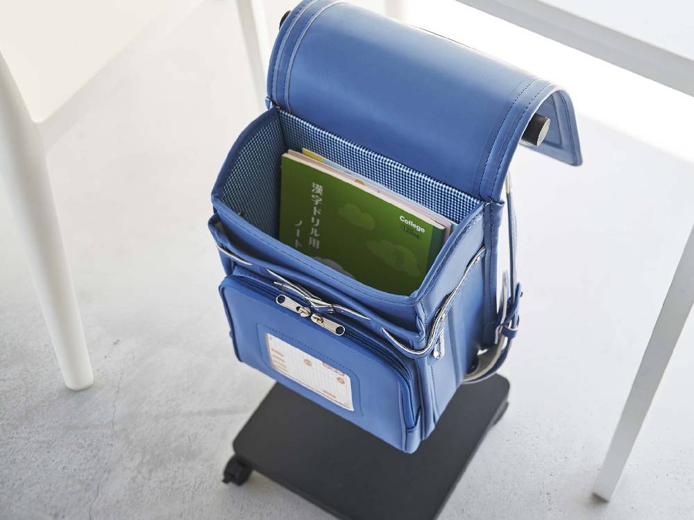 スチール製のスマートランドセル収納ワゴン。バックパックやスーツケースを整理できるポケット、ストラップ、ジッパーが付いており、耐久性のあるデザインが特徴です。