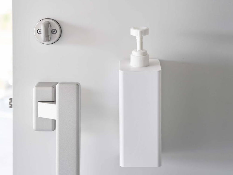 洗面所のシンクに取り付けられた【tower/タワー】マグネットアルコール除菌スプレーボトルと蛇口、ソープディスペンサーが並んでいる様子
