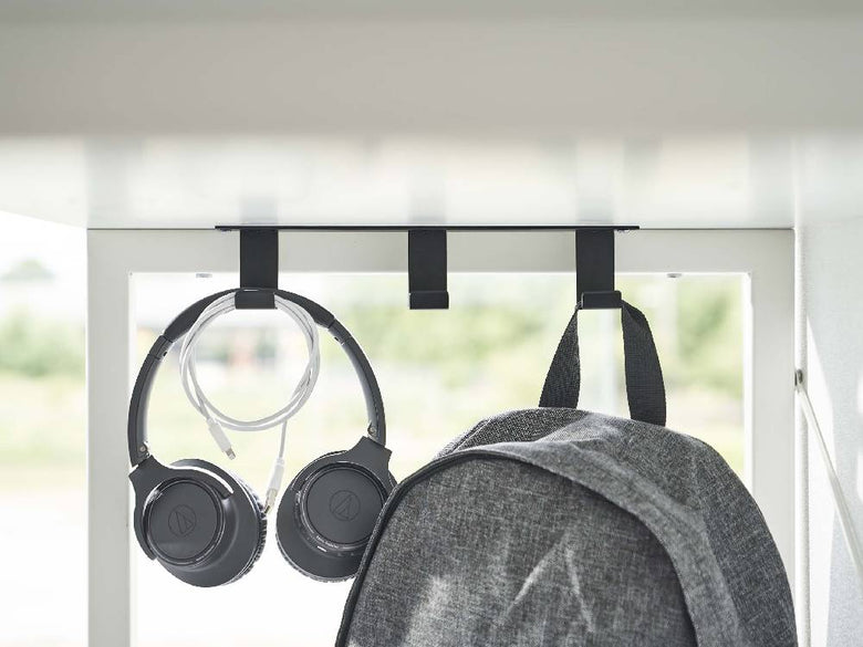 スチール製のタワー式デスク下フック3連にヘッドセットと電気ケーブルが掛かっている様子