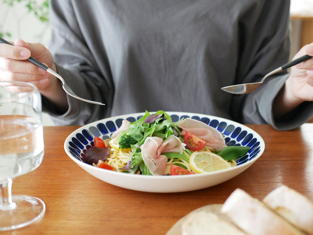 アラビア製磁器の24hトゥオキオプレートとディーププレートに盛り付けられたカラフルなサラダと果物の食卓シーン