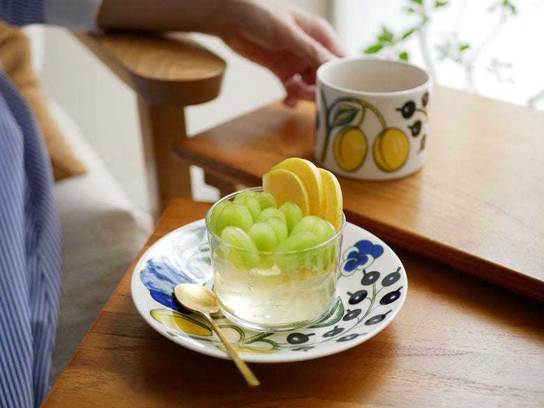 アラビア パラティッシの磁器製ティーカップとソーサーが、果物とともにテーブルに美しく配置されたセット