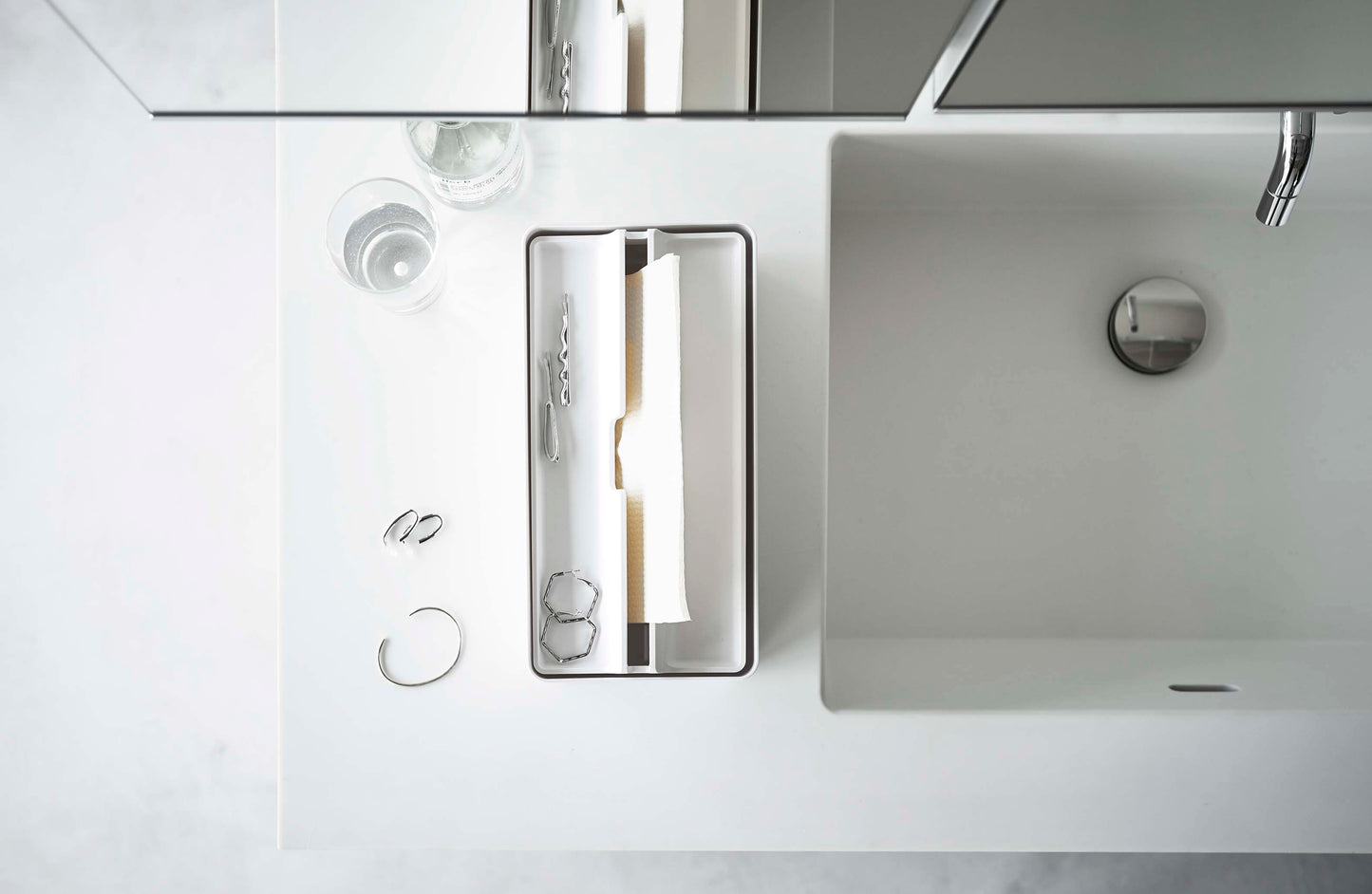 銀色の蛇口付き洗面台に置かれたトレー蓋付きペーパータオルケース【tower/タワー】。