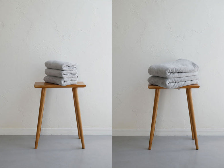 木製の家具の上にカラリデイのバスタオルとフェイスタオルが整然と並べられている様子