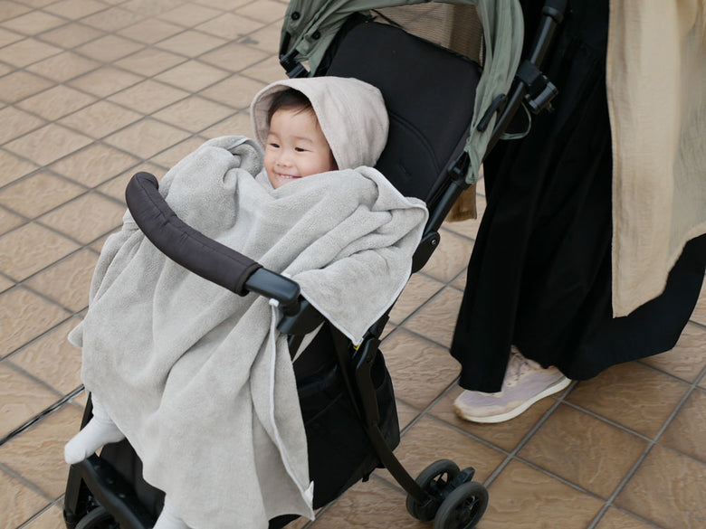 幼児がCB JAPANシービージャパンのカラリデイバスタオル2枚組とフェイスタオル3枚組を使用している様子。グレー色のポリエステルとナイロン素材で、快適さと安全性を考慮したベビー用タオルセット。