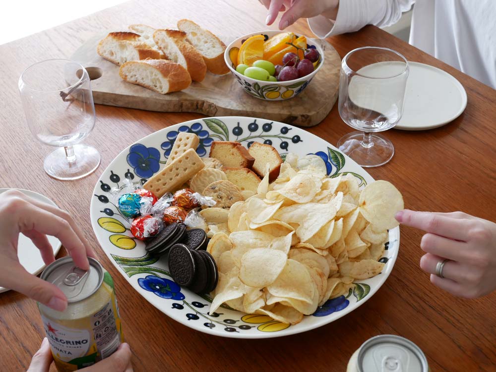 アラビアの磁器製オーバルプレートとボウル、飲み物などが揃ったテーブルセッティング