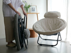 グレーの2wayフォールディングチェアが木製フローリングの床に置かれている様子