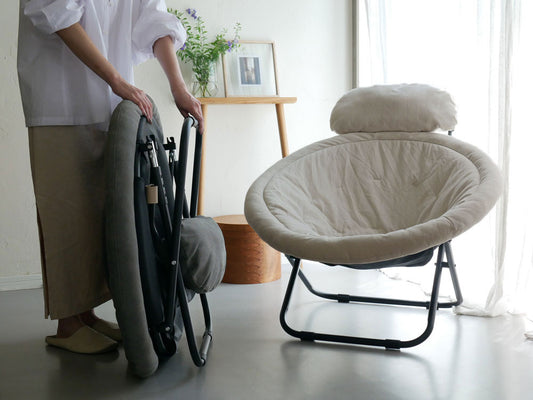 グレーの2wayフォールディングチェアが木製フローリングの床に置かれている様子