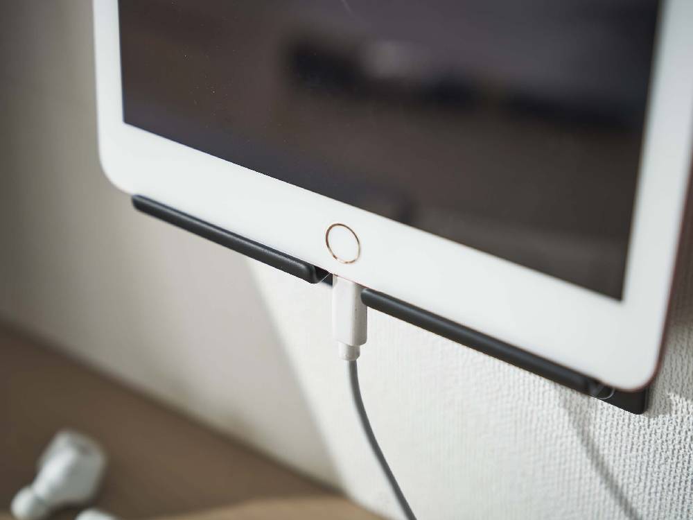 スチール製のウォールスマートフォンホルダーが壁面にしっかりと取り付けられている様子