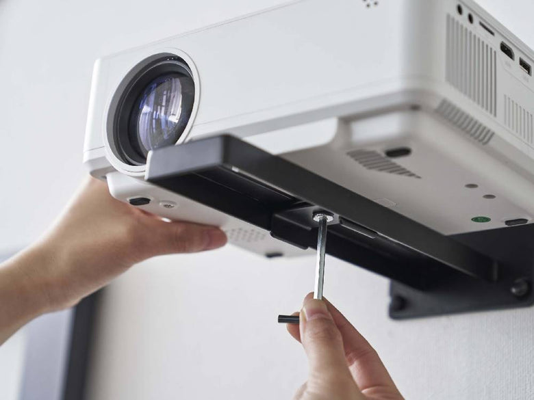 スチール製のスマートウォールプロジェクターラックが壁に取り付けられ、プロジェクターを固定している様子