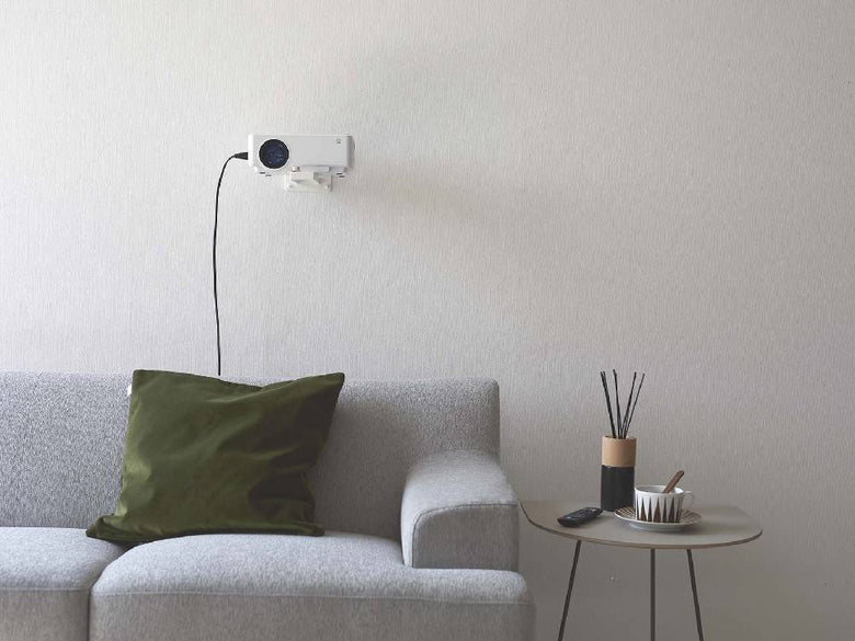 スチール製のスマートウォールプロジェクターラックにビデオプロジェクターが取り付けられ、電気ケーブルが整理された状態で壁面に設置されている様子