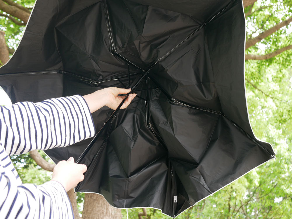 マブのグレー色プラスチック製ワイドライト遮光ミニ65傘が風に揺れている様子