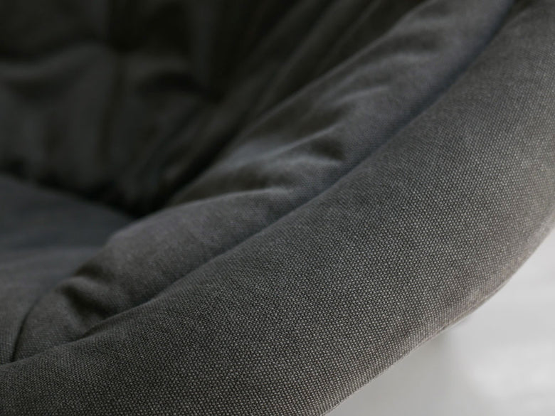 リビングルームの木製フローリング上に置かれたグレーの2wayフォールディングチェア用オットマン。レザーアームレストと快適なポリエステルクッションが特徴です。