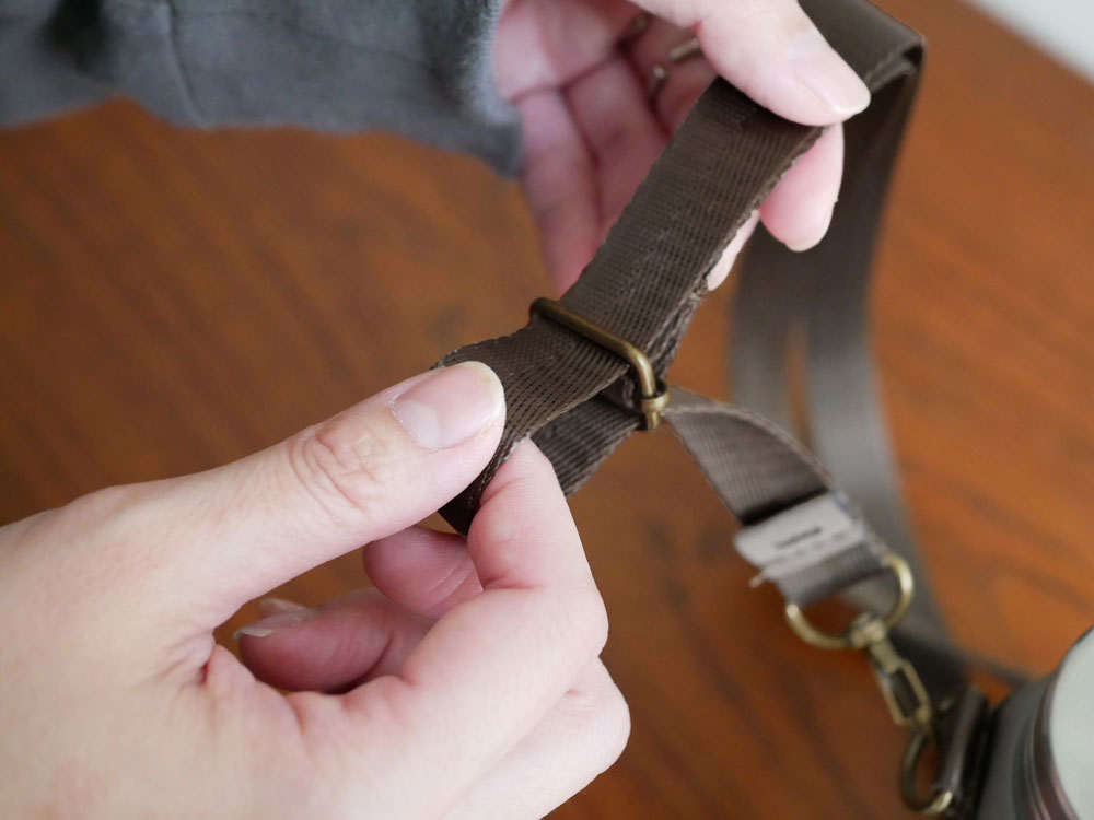 CB JAPANのHolmsオクタボトルロングショルダー。ステンレス製で340mlと460mlの容量があり、ポリエステルストラップとバックルが付いた耐久性の高いデザイン