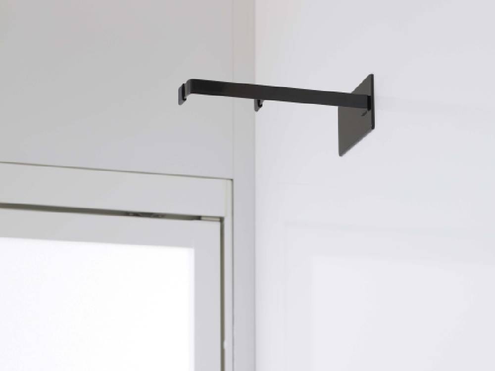 タワーマグネット浴室扉ストッパーが取り付けられた浴室のドアハンドルと鏡の写真