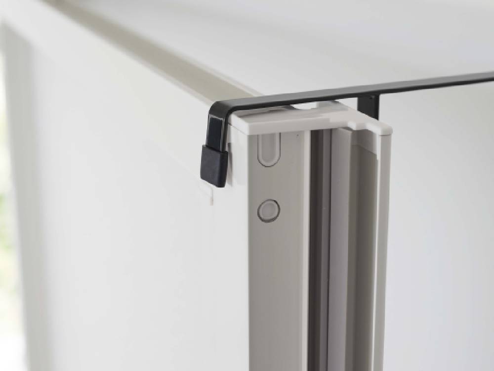 浴室のアルミ製スライディングガラス扉に「タワー」マグネット浴室扉ストッパーが取り付けられ、床やヒンジが見える様子。