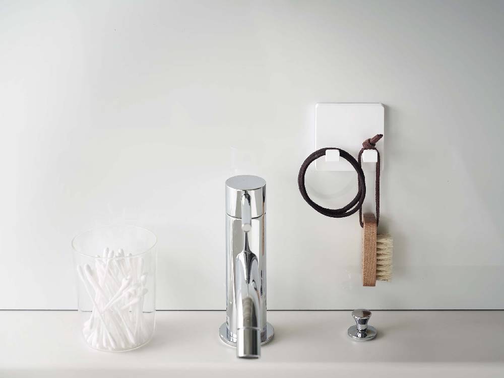 銀色のアルミニウム製MISTフィルムフック シェーバーホルダーがバスルームの壁に取り付けられている様子