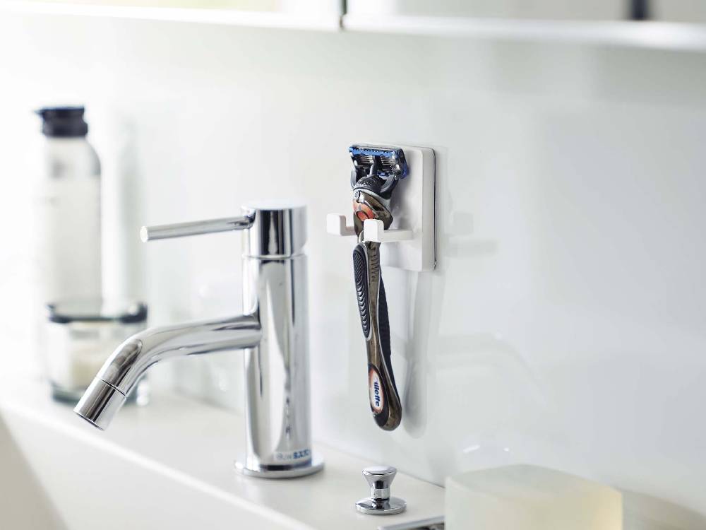 シンク周りに設置されたMISTミストフィルムフックシェーバーホルダー。銀色の蛇口や配管が背景に見える