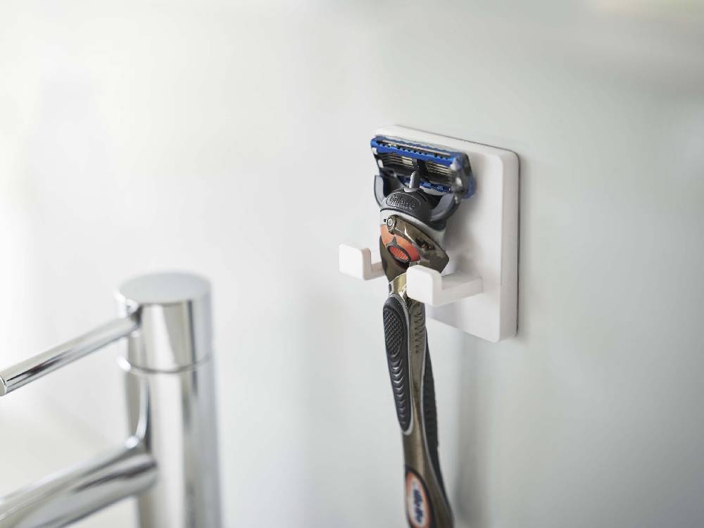 【MIST/ミスト】フィルムフック シェーバーホルダーの製品画像。幅6cmのABS樹脂本体にポリカーボネート製フィルムフックが取り付けられており、シェーバーを掛けて壁面に簡単に設置可能。