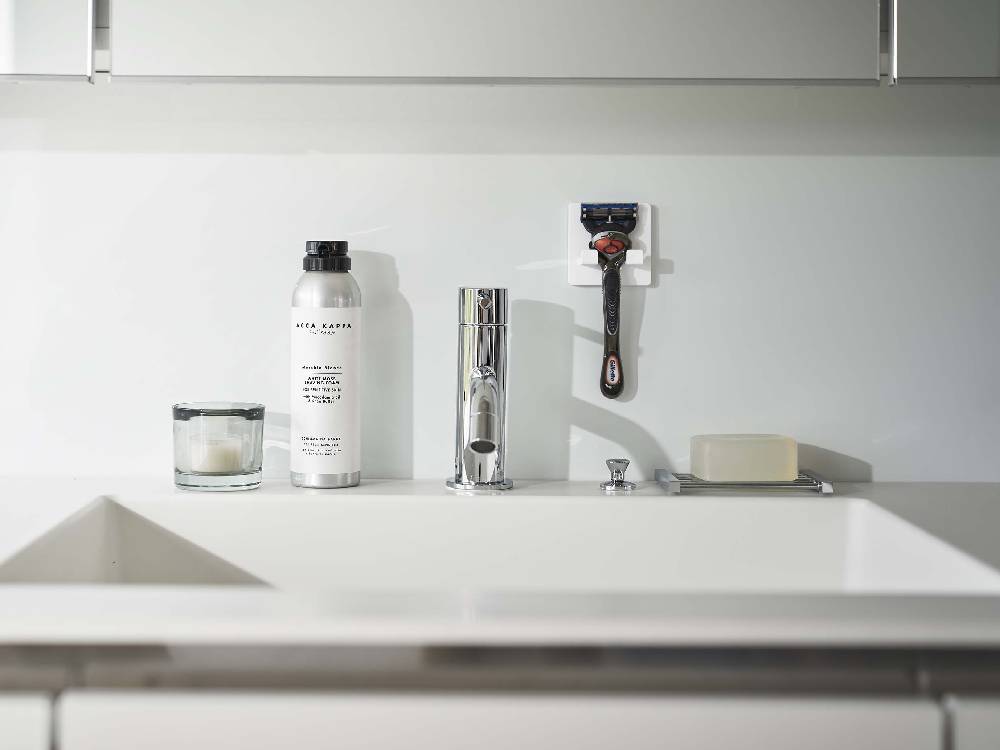 ミストのフィルムフックシェーバーホルダーがシンクカウンターに取り付けられ、シルバーのシェーバーと共に配置されたバスルームのインテリア