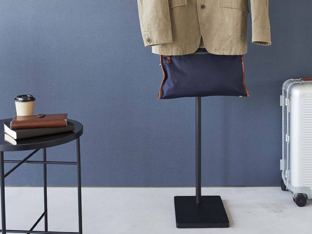 スチールと天然木で作られた高いエントランスコートハンガーが複数のフック付きで並んでいる様子