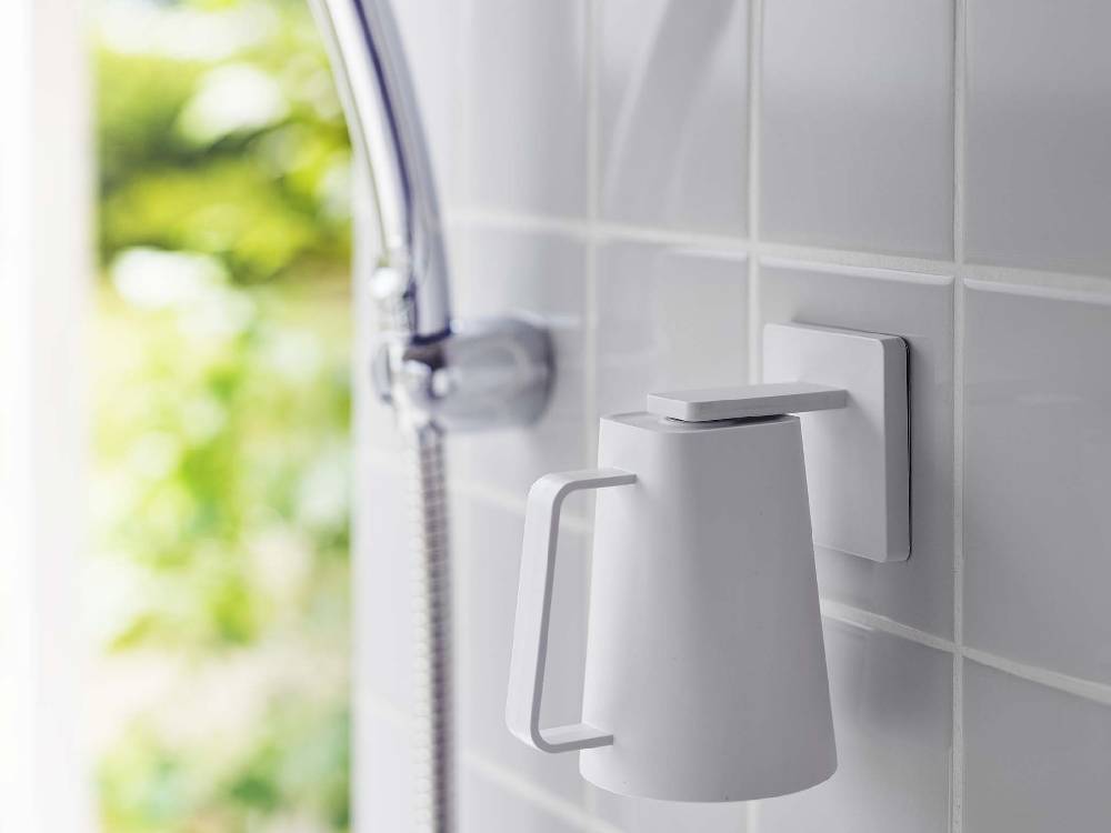 銀色の蛇口とシンクに取り付けられたマグネットタンブラー用フィルムフック、プラスチック製の家庭用ハードウェアと観葉植物が配置されたキッチン