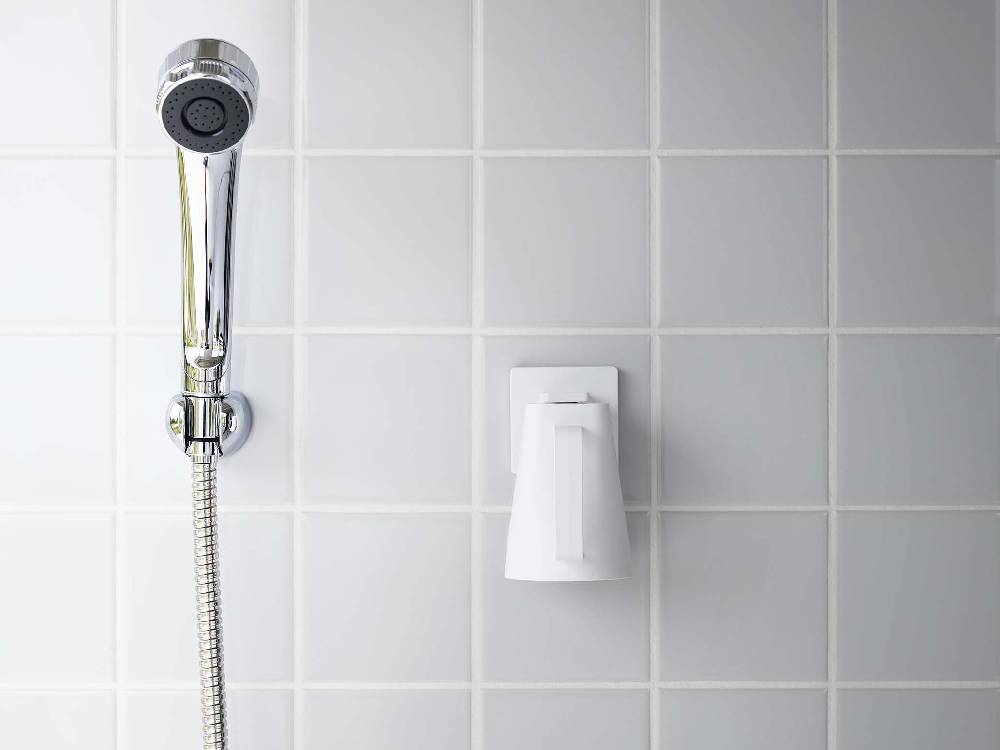 浴室の壁に取り付けられた【MIST/ミスト】フィルムフック マグネットタンブラーと近くの蛇口やシャワーヘッド