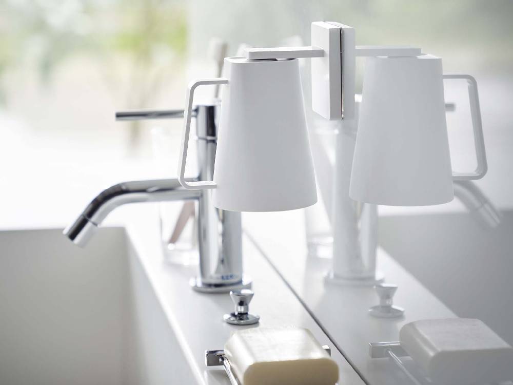 シルバーの水栓とシンクに取り付けられたミスト フィルムフック マグネットタンブラー