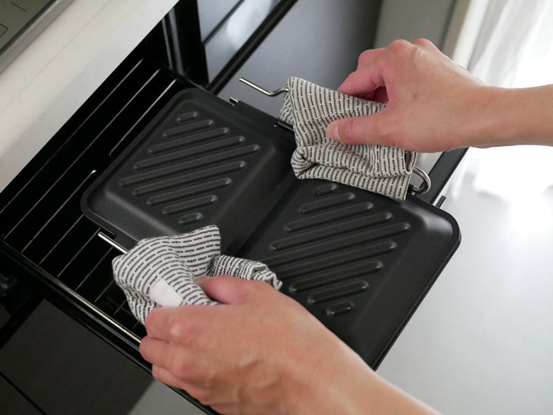 下村企販のグリルdeクック ホットサンドパンがキッチン台に置かれ、調理中のホットサンドが並ぶ様子