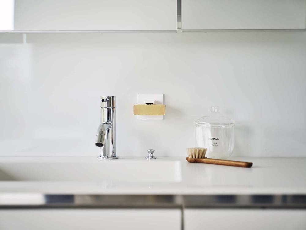 キッチンカウンタートップに取り付けられたマグネット式石鹸ホルダーとフィルムフック