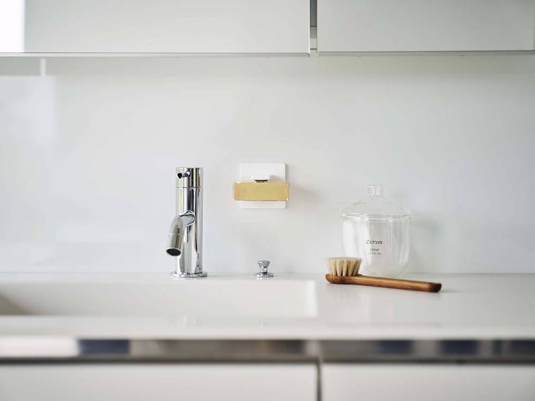 キッチンカウンタートップに取り付けられたマグネット式石鹸ホルダーとフィルムフック